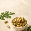 Bol de gélules DiaNatura+ avec feuilles de moringa et poudre de curcuma